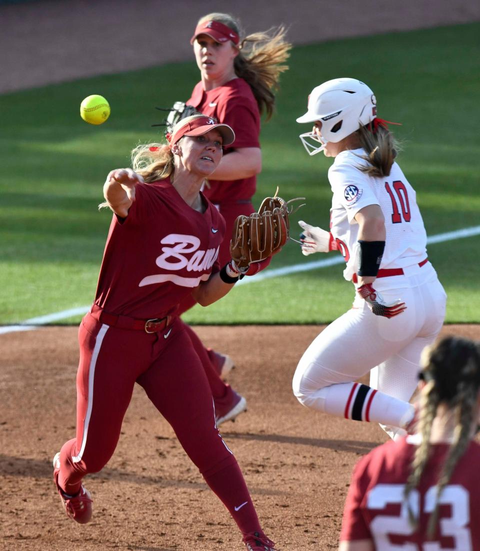 April 6, 2024; Tuscaloosa, Alabama, USA; Alabama infielder Bailey Dowling (7) throws to first to record an out as Ole Miss runner Delaney Rummell runs behind her at Rhoads Stadium Saturday. Alabama downed Ole Miss 5-1.