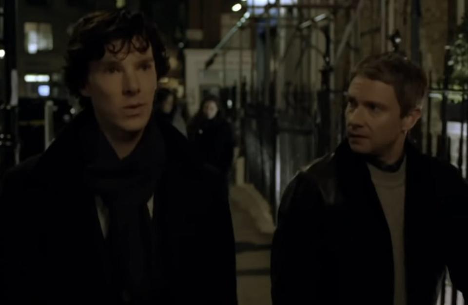 Sherlock and Watson walking down a street together at night in "Sherlock"