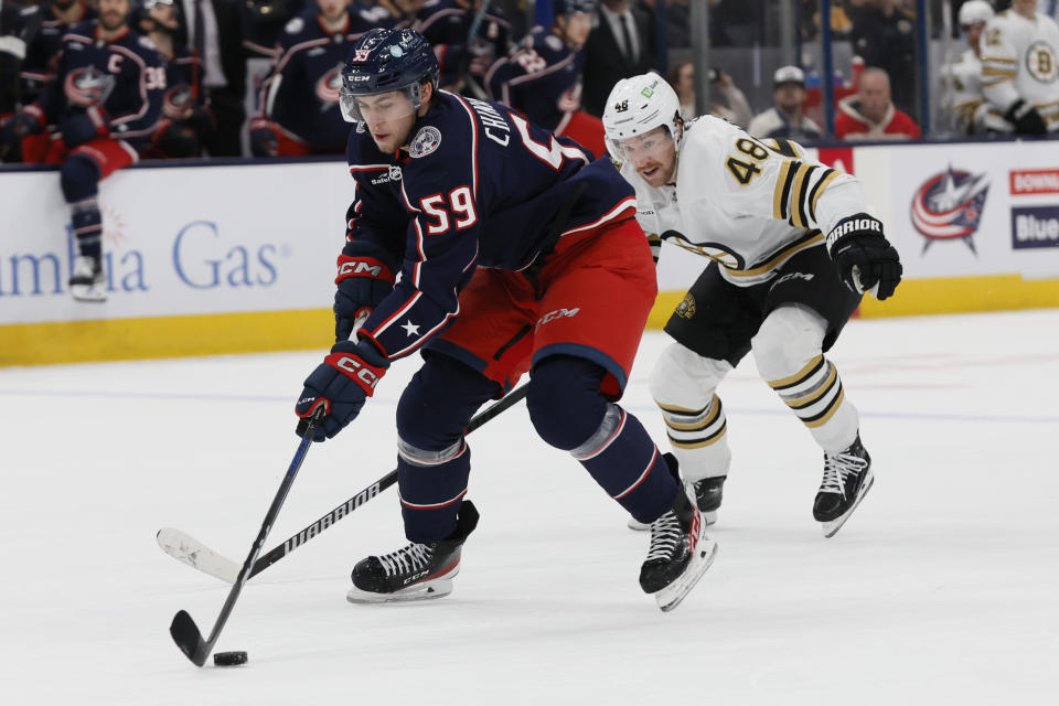 Columbus Blue Jackets' Yegor Chinakhov, left, skates past Boston Bruins' Matt Grzelcyk, right, to score a goal during the second period of an NHL hockey game Monday, Nov. 27, 2023, in Columbus, Ohio. (AP Photo/Jay LaPrete)