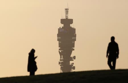 The BT communication tower is seen in the background as people walk on Primrose Hill in London February 3, 2011. REUTERS/Suzanne Plunkett