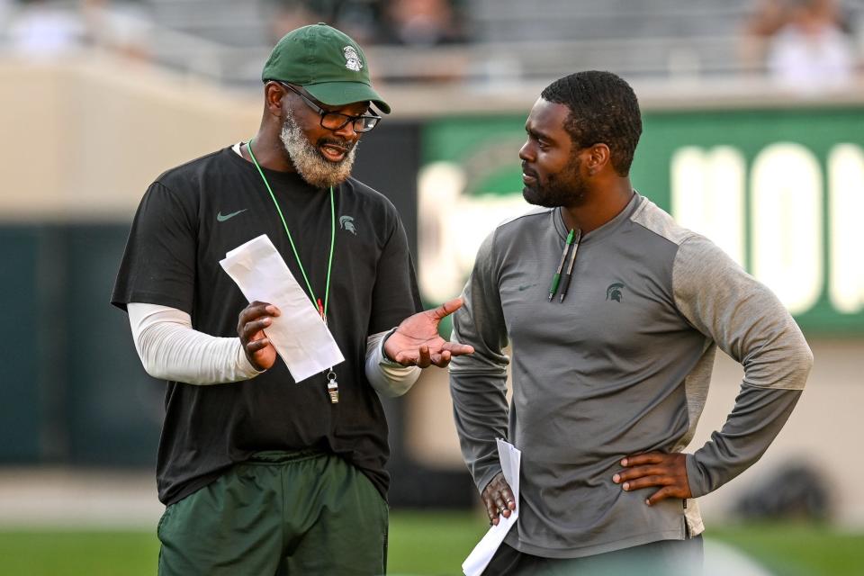 In this file photo, Michigan State's tight ends coach Ted Gilmore, left, talks with then-offensive analyst Effrem Reed during the Meet the Spartans open practice Aug. 23, 2021, at Spartan Stadium in East Lansing. Reed now is in his first season as the Spartans' running backs coach.