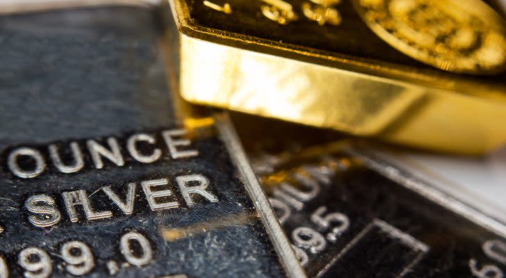 Close-up of a gold-ingot on top of a troy ounce silver and palladium bar. Precious metals. Gold, silver, palladium.