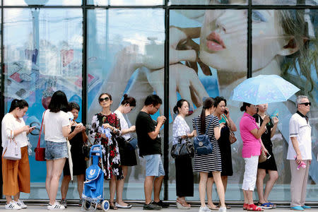 FILE PHOTO: People queue outside of a newly opened duty free shop in Shanghai, China, August 8, 2016. China Daily/via REUTERS/File Photo