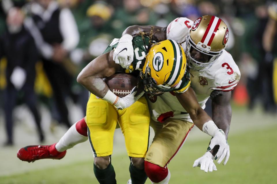 Green Bay Packers' Aaron Jones is stopped by San Francisco 49ers' Jaquiski Tartt during the first half of an NFC divisional playoff NFL football game Saturday, Jan. 22, 2022, in Green Bay, Wis. (AP Photo/Aaron Gash)