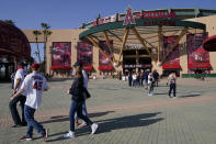 Fans walk outside Angel Stadium when a baseball game between the Minnesota Twins and the Los Angeles Angels was postponed Saturday, April 17, 2021, in Anaheim, Calif. MLB said the game was postponed to allow for continued COVID-19 testing and contact tracing involving members of the Twins organization. (AP Photo/Ashley Landis)