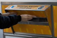 A person drops a ballot into an Official Los Angeles County Ballot Drop Box during the U.S. presidential election outside Hollywood Bowl during the outbreak of the coronavirus disease (COVID-19), in Los Angeles