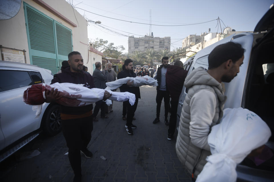 Palestinians carry relatives killed in the Israeli bombardment of the Gaza Strip outside a morgue in Kahn Younis on Friday, Dec. 8, 2023. AP Photo/Mohammed Dahman)