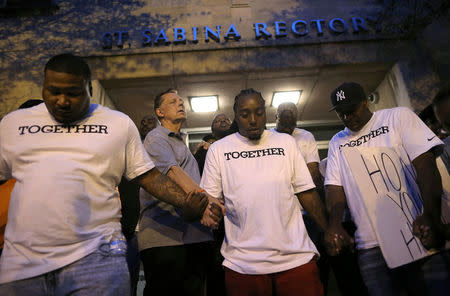 Father Michael Pfleger (2nd L) prays at Saint Sabina Church before taking part in a weekly night-time peace march through the streets of a South Side neighborhood in Chicago, Illinois, September 16, 2016. REUTERS/Jim Young