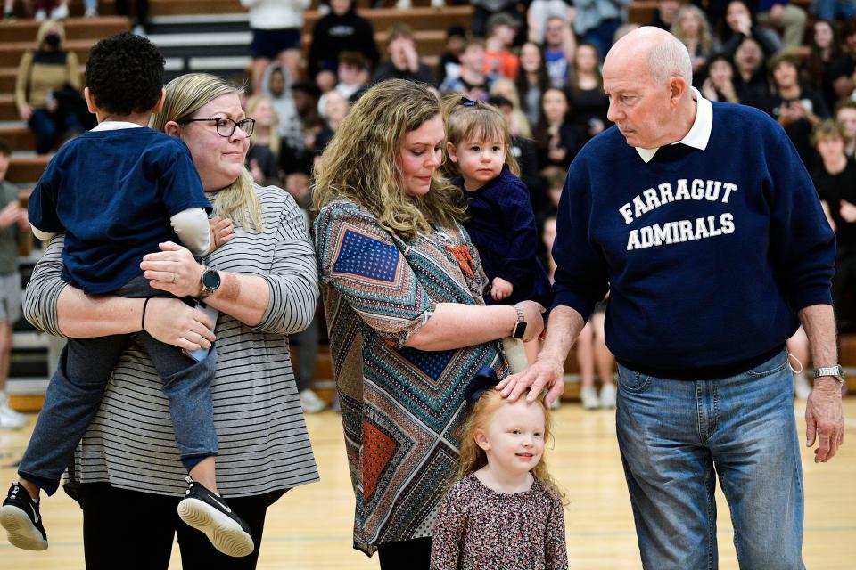 Coach Donald Dodgen, Farragut High School athletics director, with his daughters Brianne McCroskey, far left, and Whitney Dyer and grandchildren, is honored during a game in Farragut, Tenn. on Tuesday, Jan. 25, 2022. The school's gym floor was named in honor of the longtime coach.