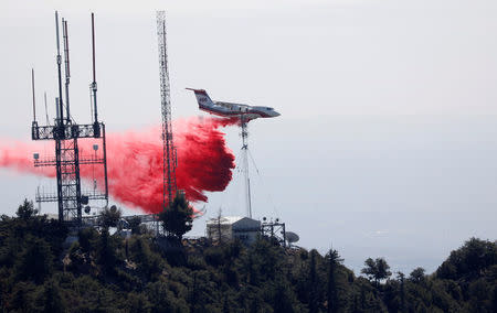 An airplane drops fire retardant while battling the Wilson Fire near Mount Wilson in the Angeles National Forest in Los Angeles, California, U.S. October 17, 2017. REUTERS/Mario Anzuoni