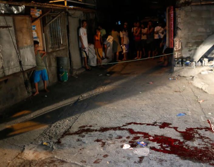 Filipino residents view a crime scene after an alleged drug user was shot dead by unidentified gunmen in Parañaque city, south of Manila, on Sept. 27, 2016. (Photo: Eugenio Loreto/EPA)