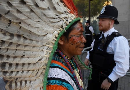 Police officers stand guard as indigenous leaders of the Huni Kuin Kaxinawa from Brazil join a protest organised by Extinction Rebellion against the Brazilian government's environmental polices, outside of the Brazilian Embassy in London, Britain