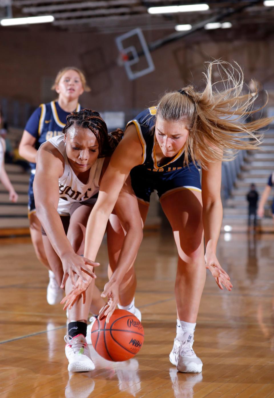 Holt's Janae Tyler, left, and Grand Ledge's Ava Scanlon vie for the ball, Friday, Dec. 16, 2022, in Holt.