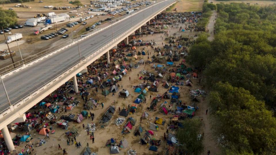 Migrants, many from Haiti, are seen at an encampment along the Del Rio International Bridge near the Rio Grande, Tuesday, Sept. 21, 2021, in Del Rio, Texas. The options remaining for thousands of Haitian migrants straddling the Mexico-Texas border are narrowing as the United States government ramps up to an expected six expulsion flights to Haiti and Mexico began busing some away from the border. (AP Photo/Julio Cortez)