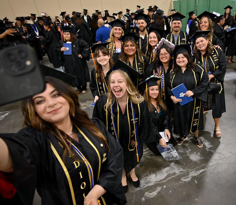 Yona Khamisi of Worcester takes a photo with fellow radiology classmates during Quinsigamond Community College commencement exercises at the DCU Center on Friday.