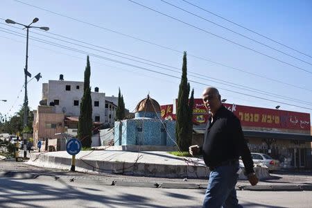 An Israeli Arab man walks past a replica of the Dome of the Rock mosque, in the Arab town of Kafr Qassem November 25, 2014. REUTERS/Nir Elias