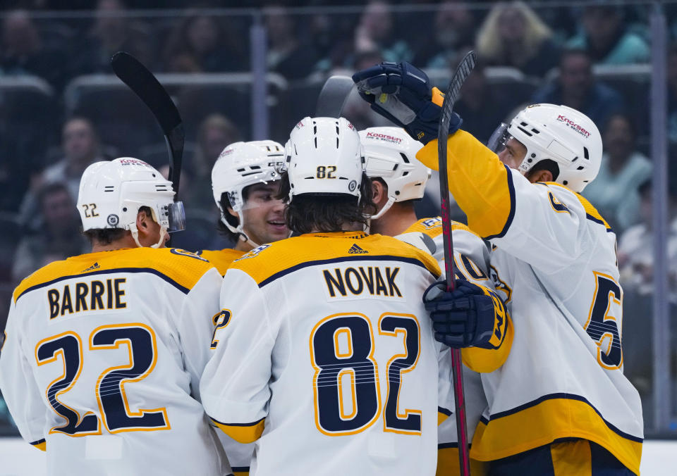 Nashville Predators center Tommy Novak (82) celebrates his goal against the Seattle Kraken with teammates, including Tyson Barrie (22) and Roman Josi, right, during the first period of an NHL hockey game Thursday, Nov. 2, 2023, in Seattle. (AP Photo/Lindsey Wasson)