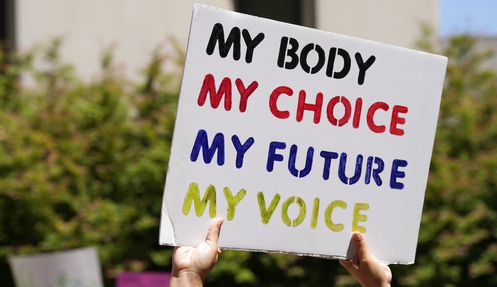 A woman supporting abortion rights holds a sign.