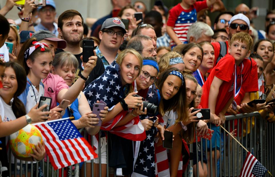 Fans cheer as members of the World Cup-winning US women's soccer team take part in a ticker tape parade for the women's World Cup champions on July 10, 2019 in New York. - Amid chants of "equal pay," "USA" and streams of confetti, the World Cup-winning US women's soccer team was feted by tens of thousands of adoring fans with a ticker-tape parade in New York on Wednesday. (Photo by Johannes Eisele/AFP/Getty Images)