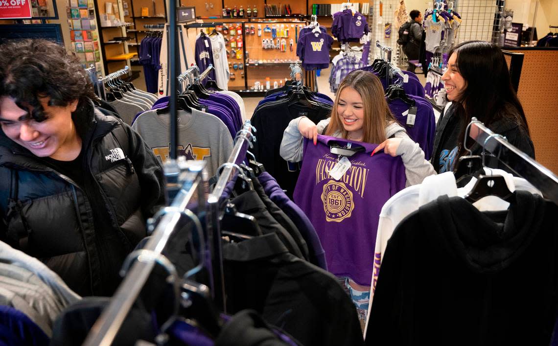 University of Washington Tacoma sophomores (from left) Pablo Reyes of Kent, Yesenia Scearcy of Puyallup, and Ashley Ramirez of Atlanta, Georgia, shop for logo apparel at the University Book Store in downtown Tacoma, Washington, on Monday, Jan. 9, 2023. The store is moving all operations to its online storefront after Friday, Jan. 13.