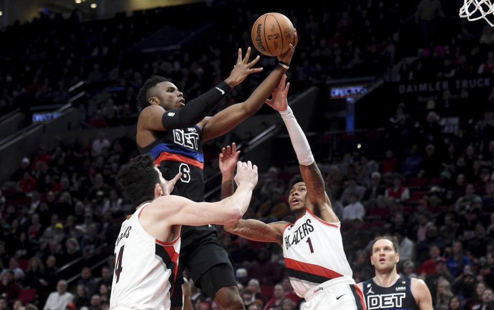 Detroit Pistons guard Hamidou Diallo, center, drives to the basket on Portland Trail Blazers forward Drew Eubanks, left, and guard Anfernee Simons, right, during the second half of an NBA basketball game in Portland, Ore., Monday, Jan. 2, 2023. The Blazers won 135-106. (AP Photo/Steve Dykes)