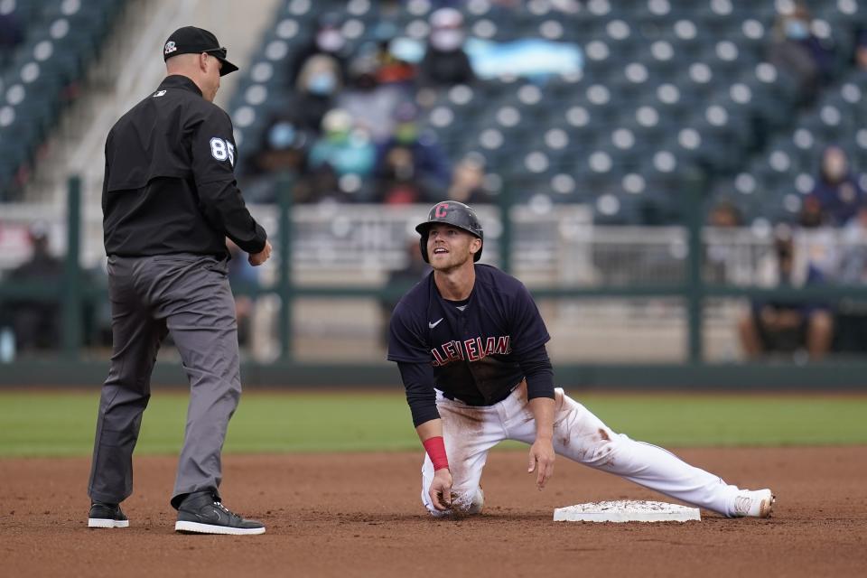 Cleveland Indians' Jake Bauers talks with umpire Nic Lentz, left, after being called out trying to steal second base during the fourth inning of a spring training baseball game against the San Francisco Giants Tuesday, March 23, 2021, in Goodyear, Ariz. (AP Photo/Ross D. Franklin)