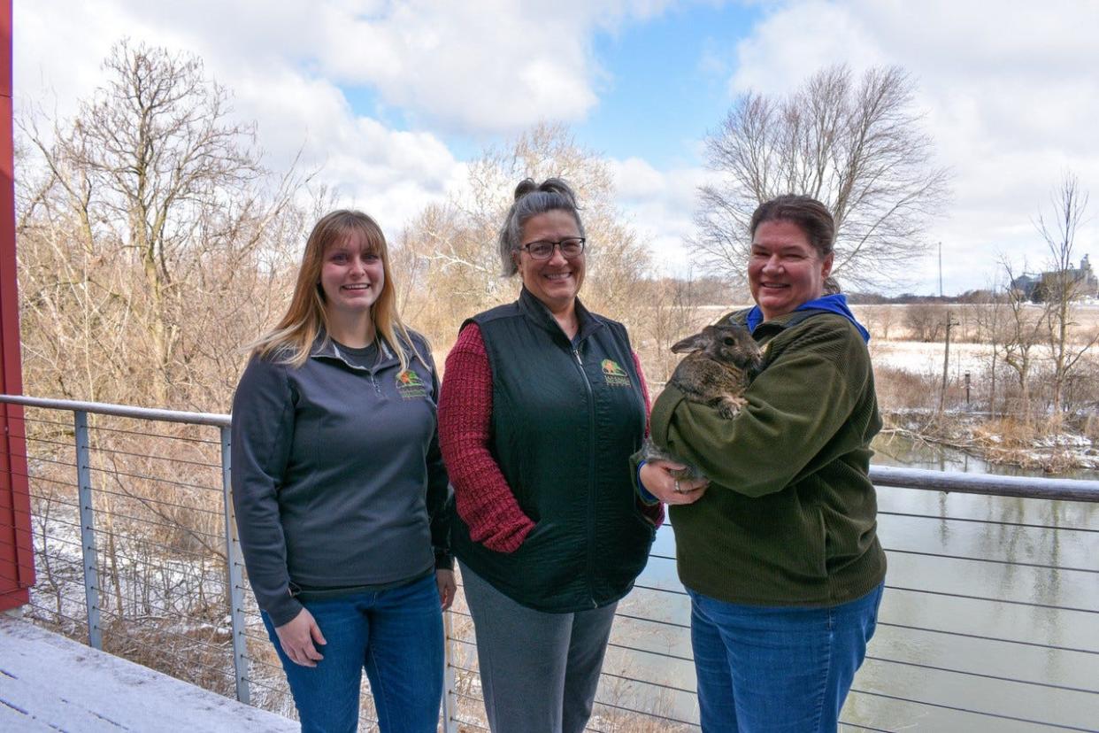 From left are Interpretive Naturalist Sarah Chong, Program Supervisor Deb Nofzinger, Naturalist Debbie Haubert, and Nibbles the rabbit. The park district staff stands on deck of the Wilson Nature Center at Creek Bend Farm in Lindsey. Creek Bend Farm is one of 18 parks the Sandusky County Park District acquired since it was formed 50 years ago.