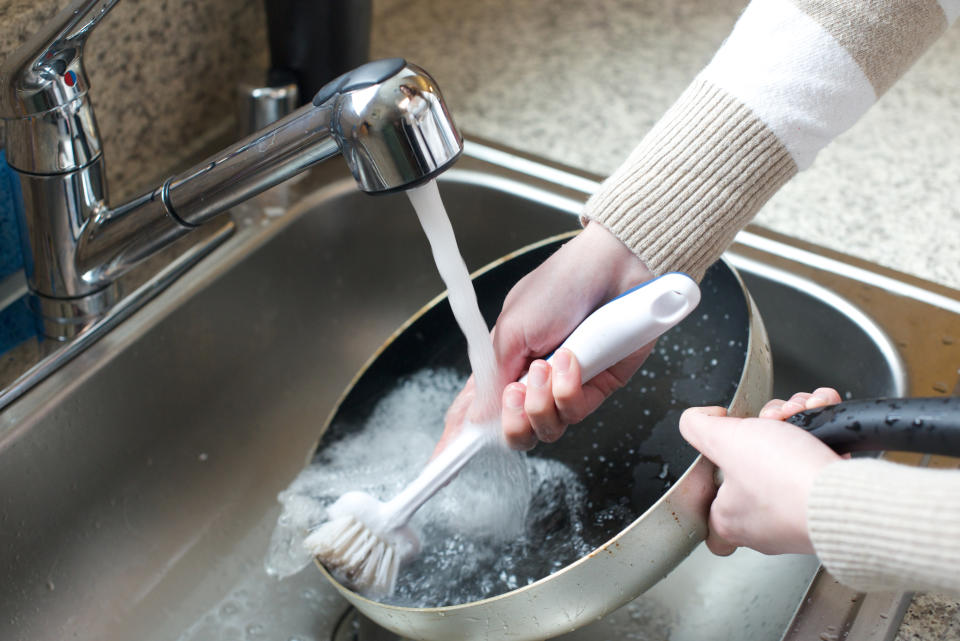 Close up of woman scrubbing pan