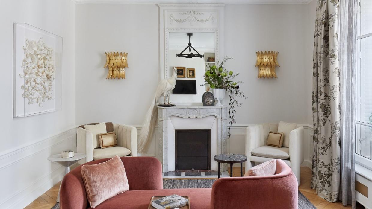  living room with pink tete a tete sofa and fireplace with two white armchairs 