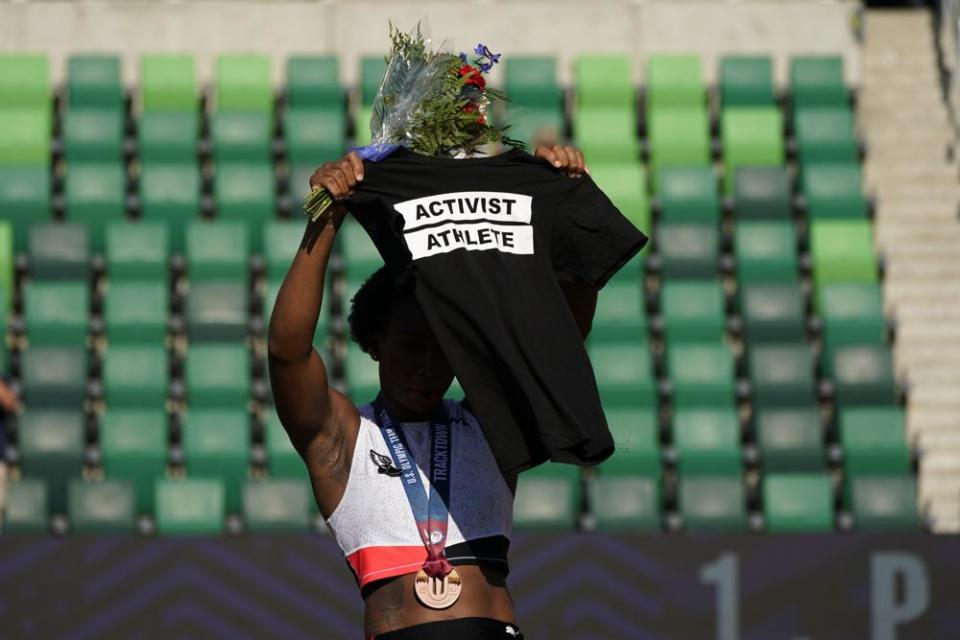 Gwendolyn Berry her Activist Athlete T-Shirt over her head during the metal ceremony after the finals of the women’s hammer throw at the U.S. Olympic Track and Field Trials Saturday, June 26, 2021, in Eugene, Ore. Berry finished third. (AP Photo/Charlie Riedel)