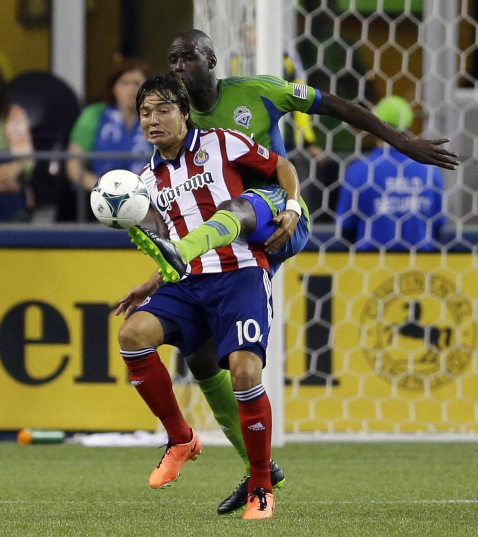 Seattle's Djimi Traore kicks the ball away from Chivas USA's Erick "Cubo" Torres during a game in September 2013.