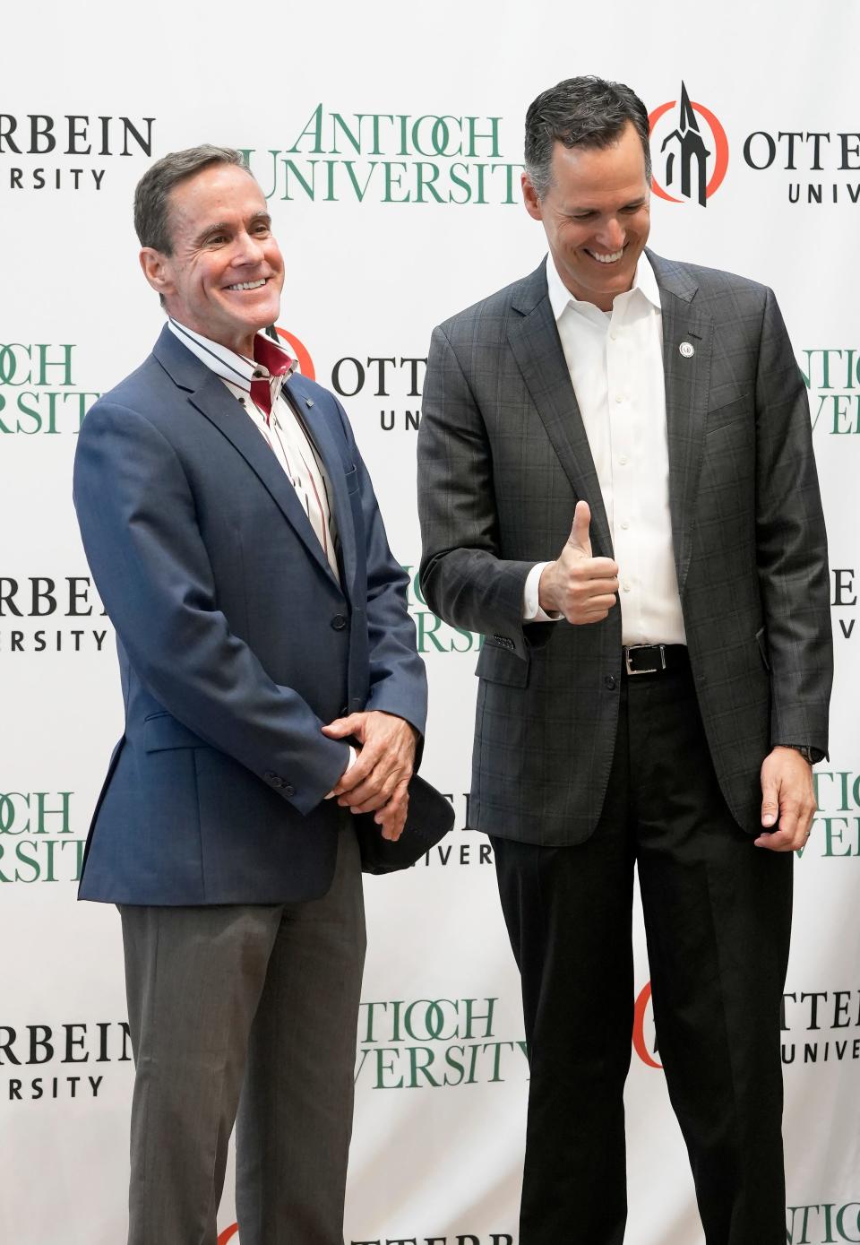 Chancellor William R. Groves of Antioch University, left, shakes hands with President John Comerford of Otterbein University, right, after a news conference announcing a partnership between the two schools in July 2022.