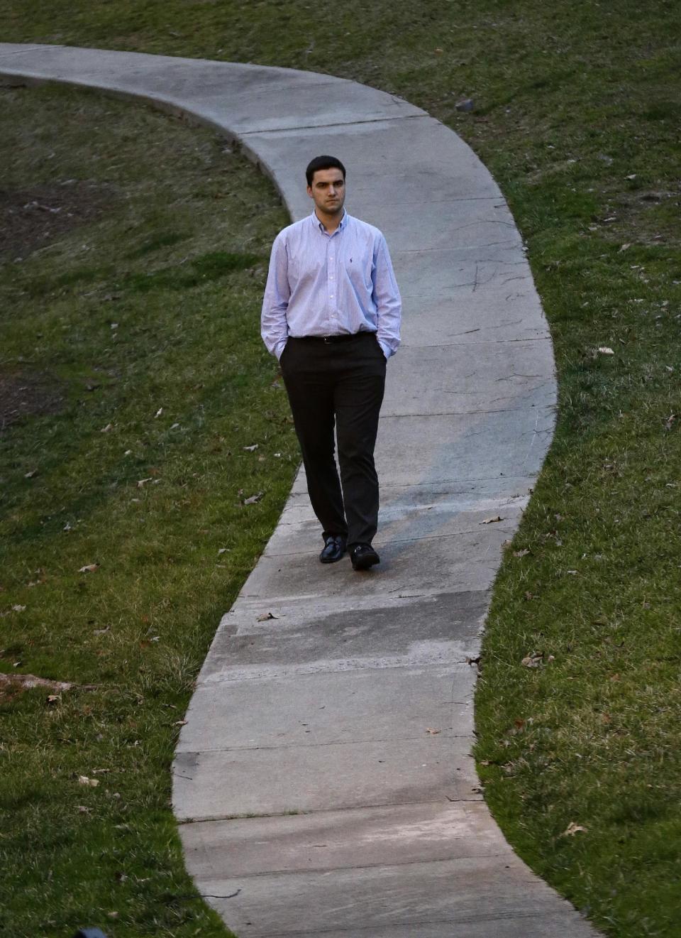 In this Thursday, Feb. 2, 2017 photo, John Cooper walks through his neighborhood in Chapel Hill, N.C. Cooper, who spent a few years working as a teacher's aide in Word of Faith Fellowship leader Jane Whaley’s class, said she encouraged the violence meant to beat out devils and warned students not to say anything to their parents. (AP Photo/Gerry Broome)