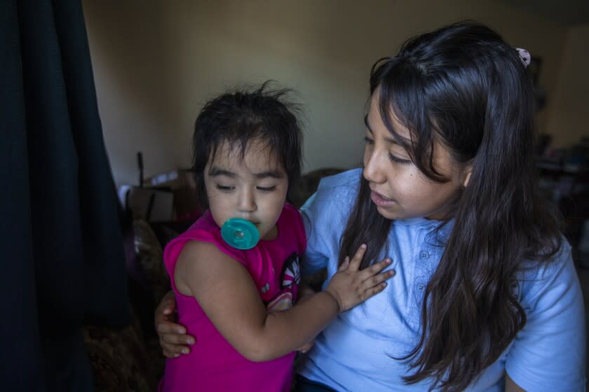 East Los Angeles, CA - August 10: Portrait of Ruby Marquez, age 2, left, with her sister Esmeralda Marquez, 11, at their home on Wednesday, Aug. 10, 2022, in East Los Angeles, CA. Esmeralda will be attending sixth grade this year. Esmeralda says she deals with anxiety when she is around others not wearing masks in public during the pandemic. Ruby, her younger sister was born prematurely and spent months in the hospital. Esmeralda explains she needs to be cautious to protect her sister who still deals with health issues. (Francine Orr / Los Angeles Times)