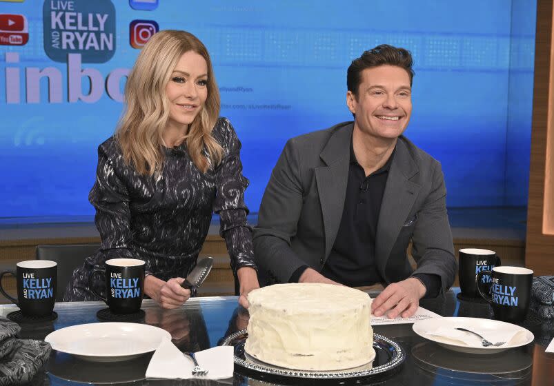 This image released by ABC shows co-host Kelly Ripa, left, and Ryan Seacrest on the set of "Live! With Kelly and Ryan" on Feb. 8, 2023 in New York. Seacrest has revealed he's leaving the show this spring. Seacrest ends a six-year run alongside Ripa and his replacement will be her real-life husband, Mark Consuelos. (Lorenzo Bevilaqua/ABC via AP)