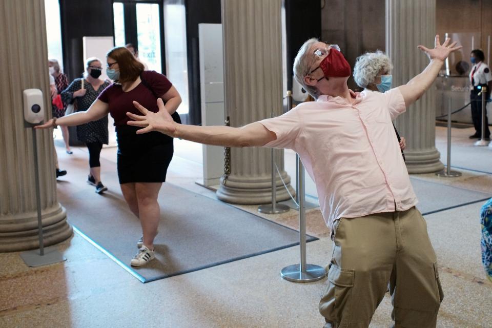 One member sanitizes their hands as another member celebrates at the Metropolitan Museum of Art during its first day open to members since March on August 27, 2020.