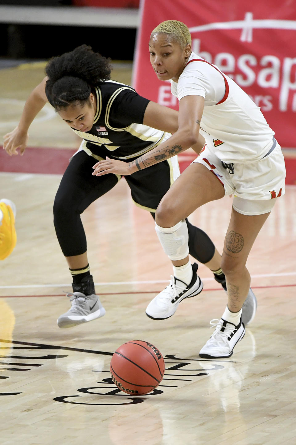Purdue guard Jenelle Grant (22) and Maryland forward Alaysia Styles (5) go after a loose ball during the second half of an NCAA college basketball game, Sunday, Jan. 10, 2021, in College Park, Md. (AP Photo/Will Newton)