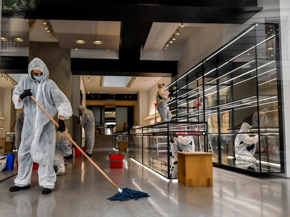 Workers wearing protective outfits sanitize a shop in via Monte Napoleone fashion shopping street, in Milan, Italy, Monday, April 27, 2020.  Italian factories, construction sites and wholesale supply businesses can resume activity as soon as they put safety measures into place aimed at containing contagion with COVID-19. This concession comes with partial easing of national lockdown restrictions announced Sunday night by Italian Premier Giuseppe Conte. (Claudio Furlan/LaPresse via AP)