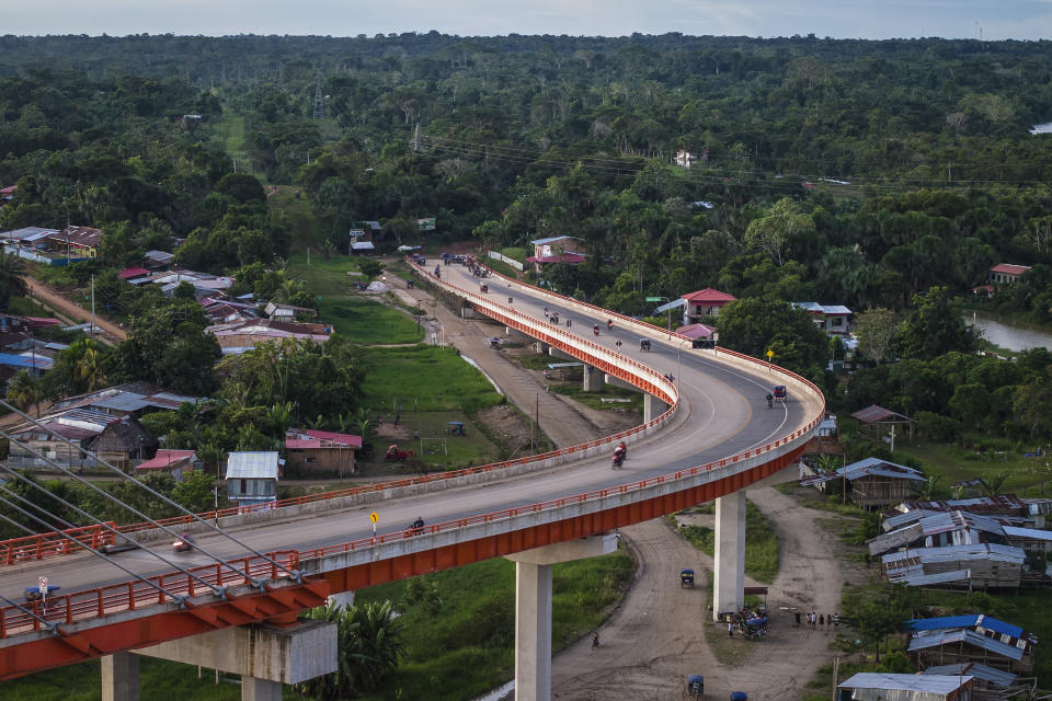 Residents drive on a bridge, part of a federal highway project that extends over the Nanay River, in Iquitos, Peru, Sunday, May 26, 2024. Construction work is at a standstill as the government conducts a study of the area, but the Ministry of Transportation has already built what is the country's largest bridge, which extends 2.3 kilometers (1.4 miles) over the Nanay, a tributary of the Amazon River. (AP Photo/Rodrigo Abd)