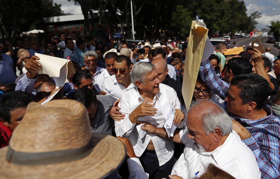 Mexican President-elect Andres Manuel Lopez Obrador walks through supporters as he holds an event in Tepic, Mexico, Sunday, Sept. 16, 2018. The president-elect kicked off his nationwide tour with a new security group of 20 people who will rotate five at a time to accompany him everywhere, with the goal of allowing the incoming president to interact with voters without getting squashed. (AP Photo/Eduardo Verdugo)