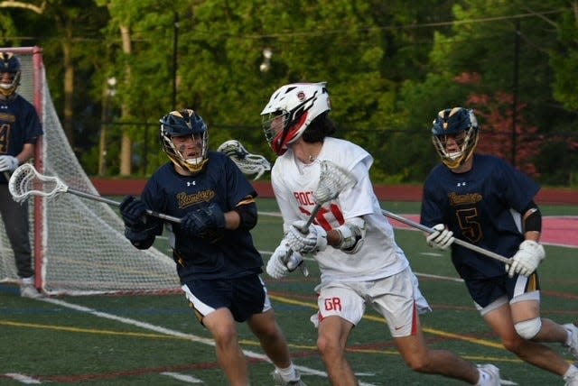 Glen Rock's Robbie Drace (10) is watched by two Ramsey defenders during the North Group 1 boys lacrosse semifinal. May 25, 2022.