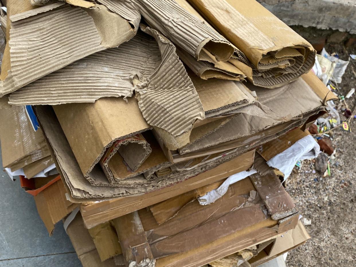 Stock photo showing close-up view of piles of flattened cardboard boxes for recycling at a waste plant.