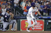 Houston Astros' Joey Loperfido, right, flips his bat as he heads to first base on his two run RBI single in front of Cleveland Guardians catcher Bo Naylor, left, during the fourth inning of a baseball game Tuesday, April 30, 2024, in Houston. Loperfido's hit was his first in the major leagues. (AP Photo/Michael Wyke)