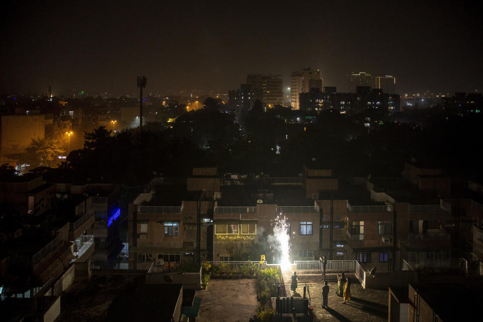 People light firecrackers on the terrace of a building during Diwali celebrations in New Delhi, India, Thursday, Nov. 4, 2021. Diwali, the festival of lights, is one of Hinduism's most important festivals dedicated to the worship of Lakshmi, the Hindu goddess of wealth. (AP Photo/Altaf Qadri)