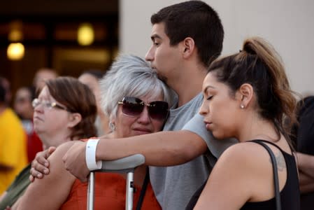 Justin Bates, a survivor of the Gilroy Garlic Festival mass shooting, comforts his mother, Lisa Barth, and sister Stephanie Bates, during a vigil outside of Gilroy City Hall