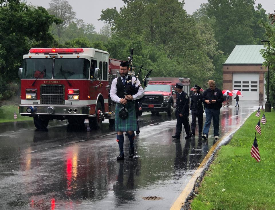 Bagpiper Andrew Duncan leads the Cheshire Memorial Day parade through the rain on Saturday.