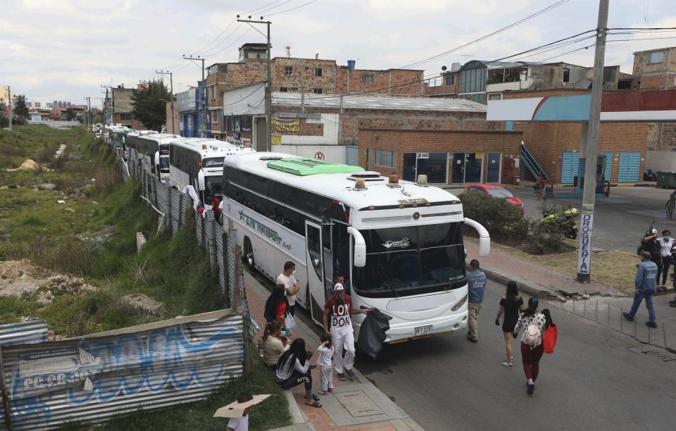 In this April 30, 2020 photo, Venezuelan migrants board buses departing to the Venezuelan border amid the new coronavirus pandemic, in Bogota, Colombia. About 20,000 Venezuelans returned home since early March due to the pandemic's economic fallout. (AP Photo/Fernando Vergara)