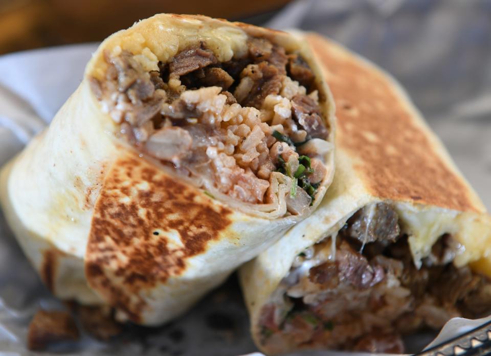 This is one of the Comal 864's burritos which is made of: rice, beans, cheese, chopped steak, pico de gallo, crema, with hot sauce.
(Photo: ALEX HICKS JR./STAFF)