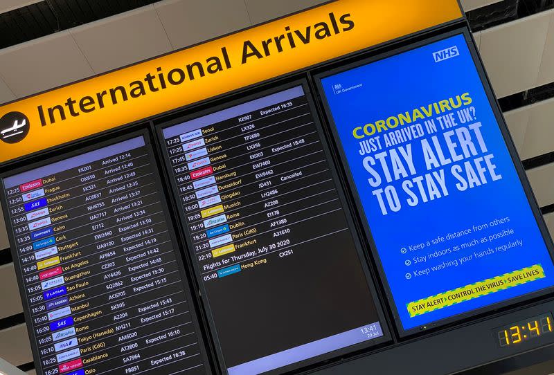 FILE PHOTO: A public health campaign message is displayed on an arrivals information board at Heathrow Airport, following the outbreak of the coronavirus disease (COVID-19), London, Britain