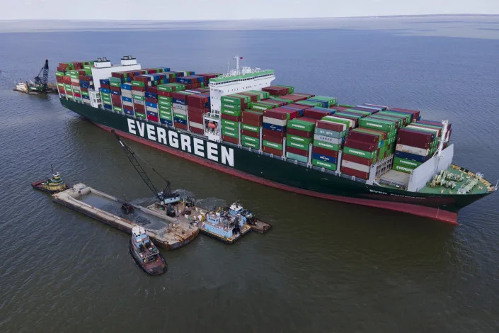 Crews dredge near the container ship Ever Forward in efforts to free it after it ran aground off the coast near Pasadena, Md., Monday, March 21, 2022. The ship isn't blocking navigation in the channel, unlike last year's high-profile grounding in the Suez Canal of its sister vessel, the Ever Given, which disrupted the global supply chain for days. (AP Photo/Julio Cortez)